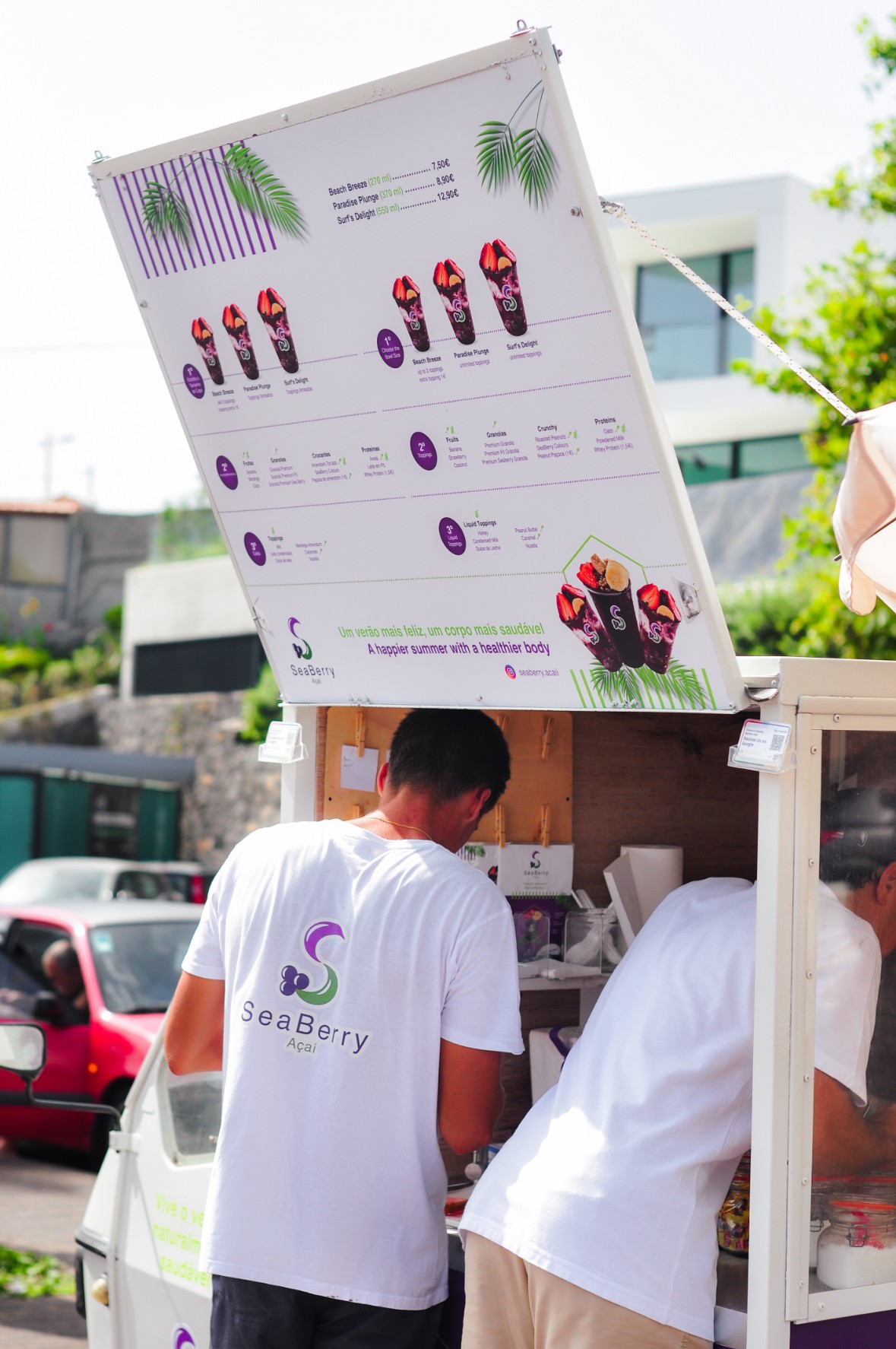 Dois colaboradores SeaBerry servindo açaí na praia — açaí fresco Machico